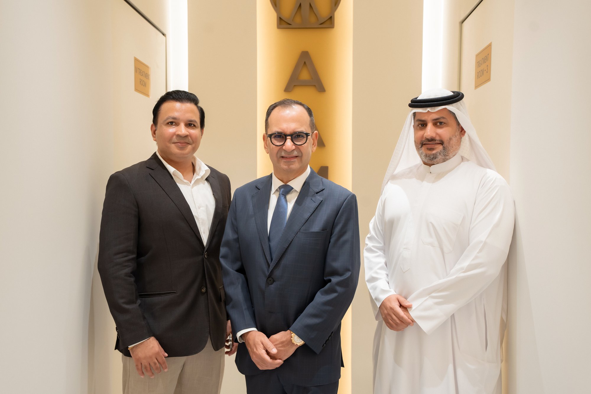 Three people photographed together inside AAMC Polyclinic during the opening.
